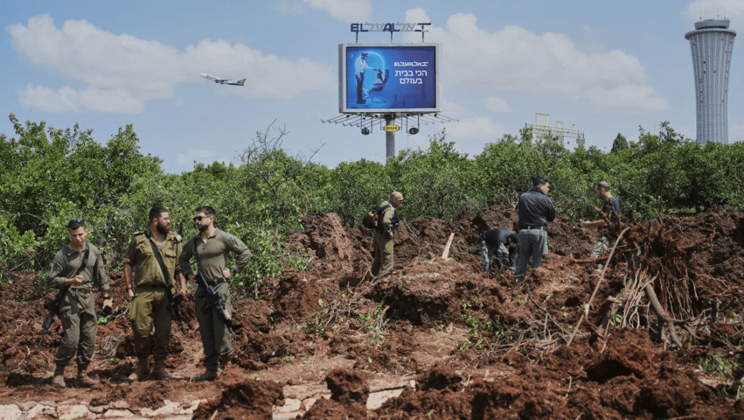 Debris from missile strike near Ben Gurion Airport with smoke rising.