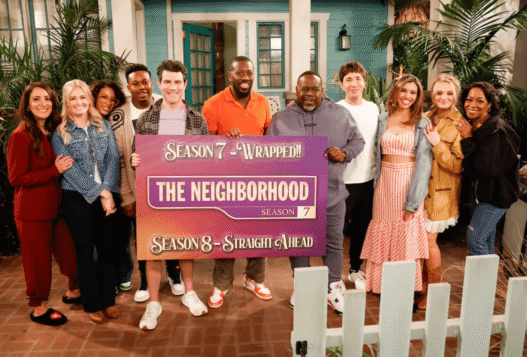 Cedric the Entertainer with cast members on the set of The Neighborhood, discussing Malcolm’s new chapter in Venice