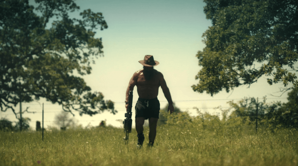 Brian Johnson, aka The Liver King, sits shirtless by a fire during an interview in Netflix’s Untold