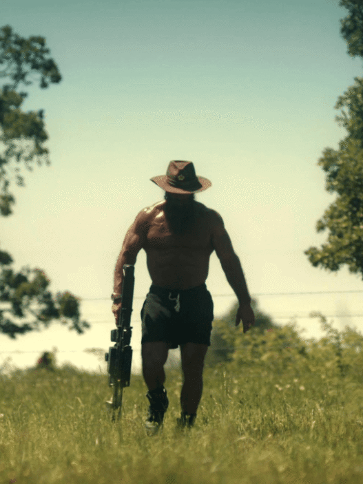 Brian Johnson, aka The Liver King, sits shirtless by a fire during an interview in Netflix’s Untold