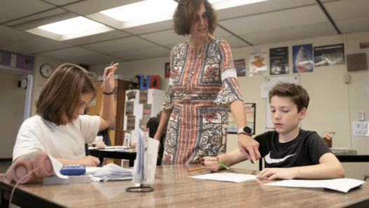 Teacher receiving a thank-you card and gift from a student during Teacher Appreciation Week.