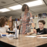 Teacher receiving a thank-you card and gift from a student during Teacher Appreciation Week.