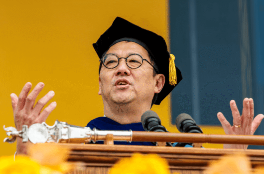 Santa Ono speaking at a podium during a University of Michigan event.