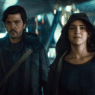Cassian Andor stands amid a chaotic street scene during the Ghorman uprising in Andor Season 2, Episode