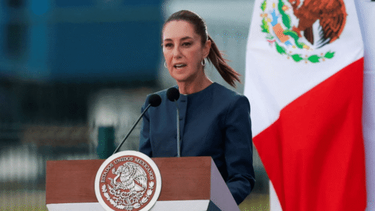 Mexican President Claudia Sheinbaum speaking at a podium during a press conference
